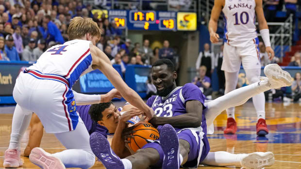 Jan 31, 2023; Lawrence, Kansas, USA; Kansas State Wildcats center Abayomi Iyiola (23) battles for a loose ball against Kansas Jayhawks guard Gradey Dick (4) and guard Kevin McCullar Jr. (15) during the second half at Allen Fieldhouse. Mandatory Credit: Jay Biggerstaff-USA TODAY Sports